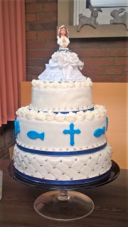 Eine dreistöckige Torte zur Kommunion mit passender Figur.